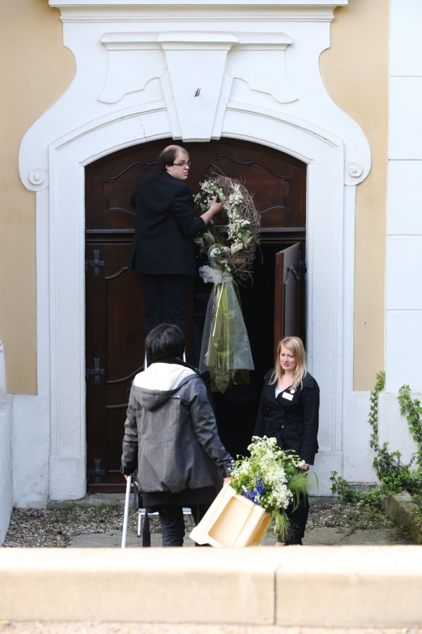 Vchod kostela je ozdoben svatebním věncem.