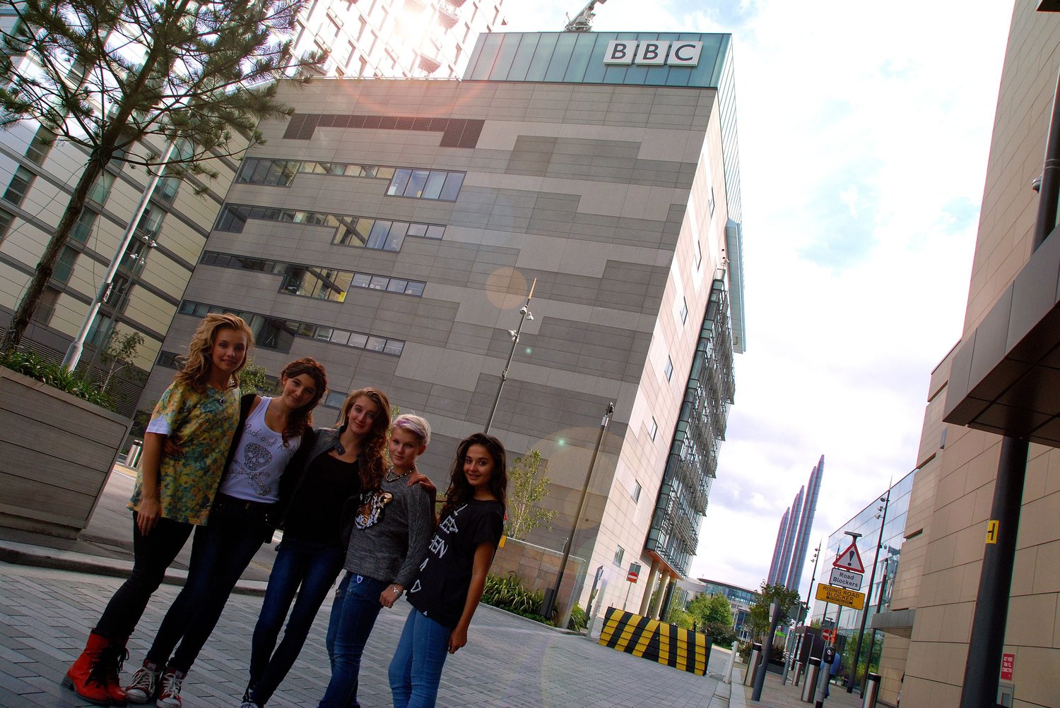 5Angels před budovou BBC, ve které natáčely pořad, o jehož sledovanosti management kapely výslovně lže.