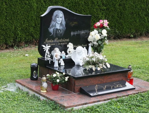 Hrob Ivety Bartošové je obložen květinami.