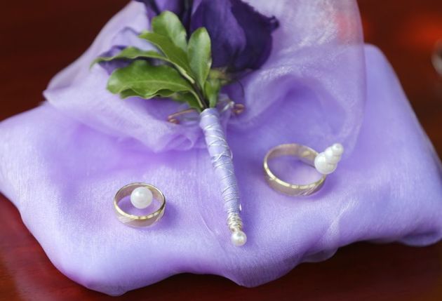 Snubní prsteny s perličkami, jak jinak než na fialovém ubrousku.