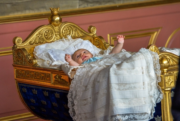 Tříměsíční princ Oscar měl při svém křtu starodávnou zdobenou kolébku.