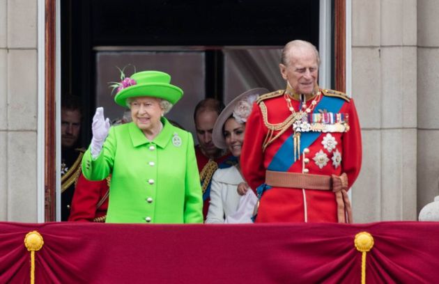 Královna zdraví gratulanty z řad lidu a po boku jí stojí manžel princ Philip.