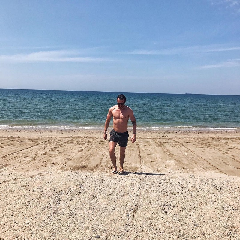 Moderátor na pláži ukazoval svaly.