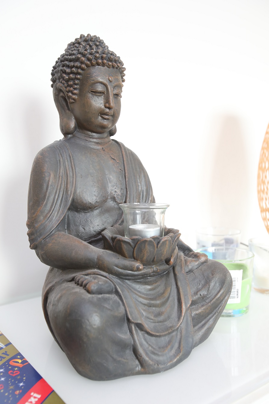 Socha Buddhy se svícnem pomáhá harmonizaci bydlení.