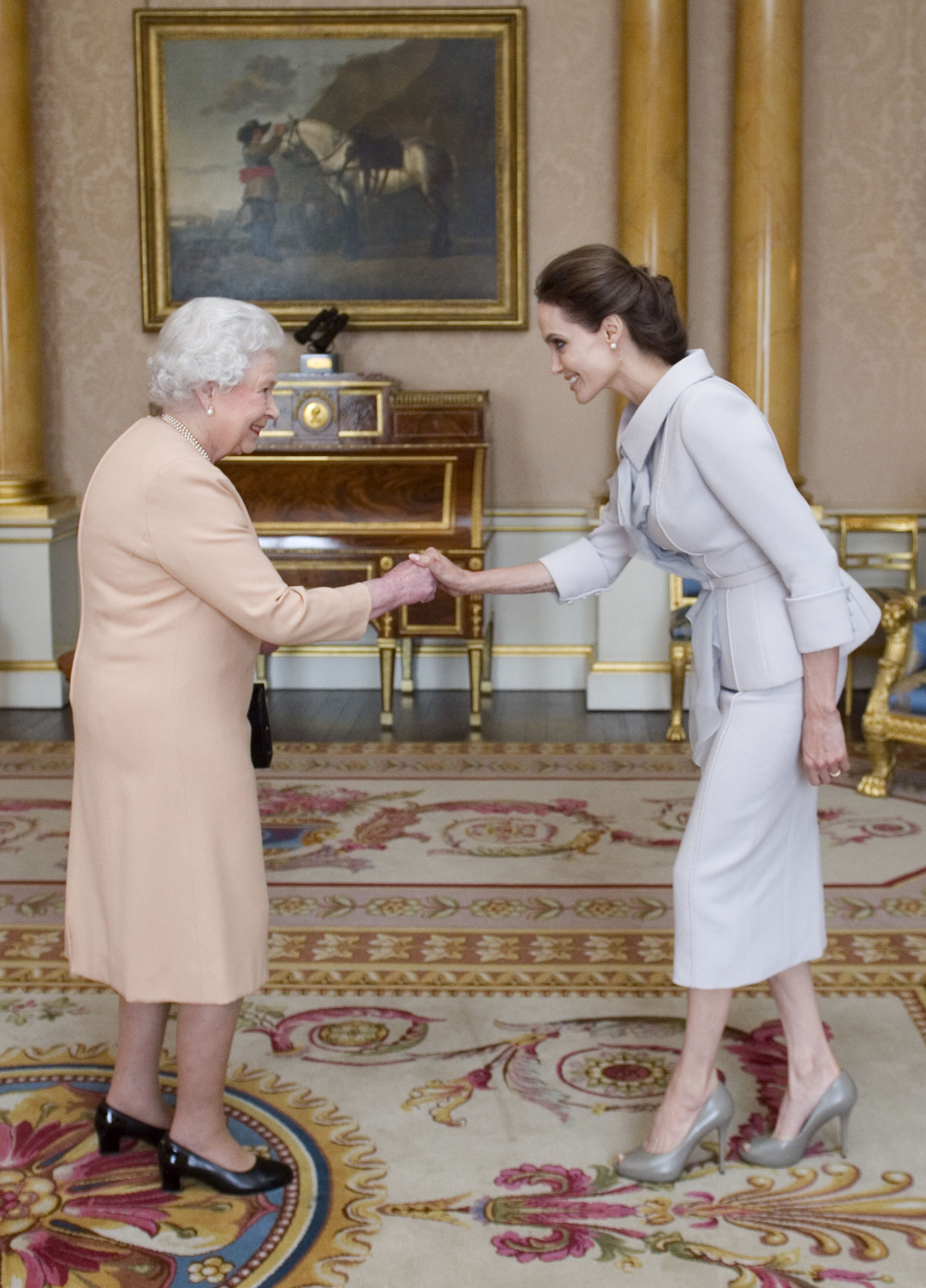 Angelina Jolie od královny v roce 2014 obdržela Řád britského impéria za své zásluhy v boji proti sexuálnímu násilí ve válečných zónách. Šedý kostýmek, který oblékla, se pro podobnou událost perfektně hodí.