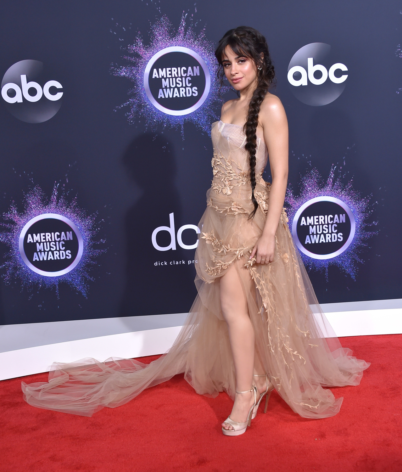 Zpěvačka Camila Cabello zvolila éterické šaty tělové barvy, které doplnila o dlouhý cop.