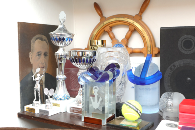 Police zdobí řada dekorativních předmětů například poháry z tenisových zápasů.