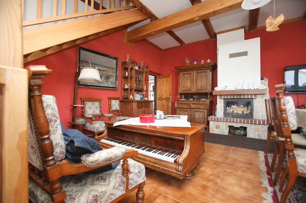 Obýváku, jenž je zařízen ve venkovském stylu, vévodí staré piano, které slouží jako konferenční stůl.