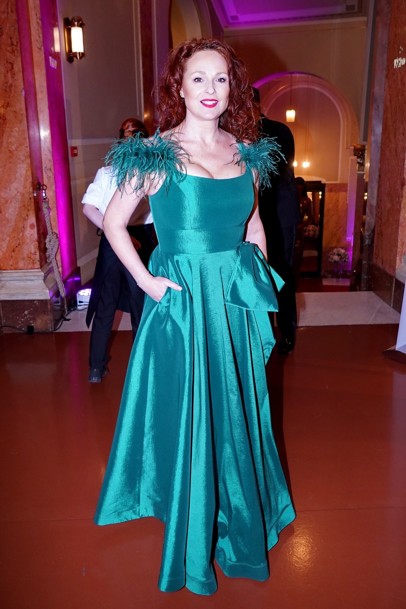 Tohle je opravdu špatně. Barva by nebyla zlá, ale měla zvolit jiný materiál. Tento lesklý taft satén je ve větším množství velice laciný. Péřové detaily to bohužel dělají ještě horší. Markéta Hrubešová působí mohutně a neforemně. Špatně zvolila i líčení.