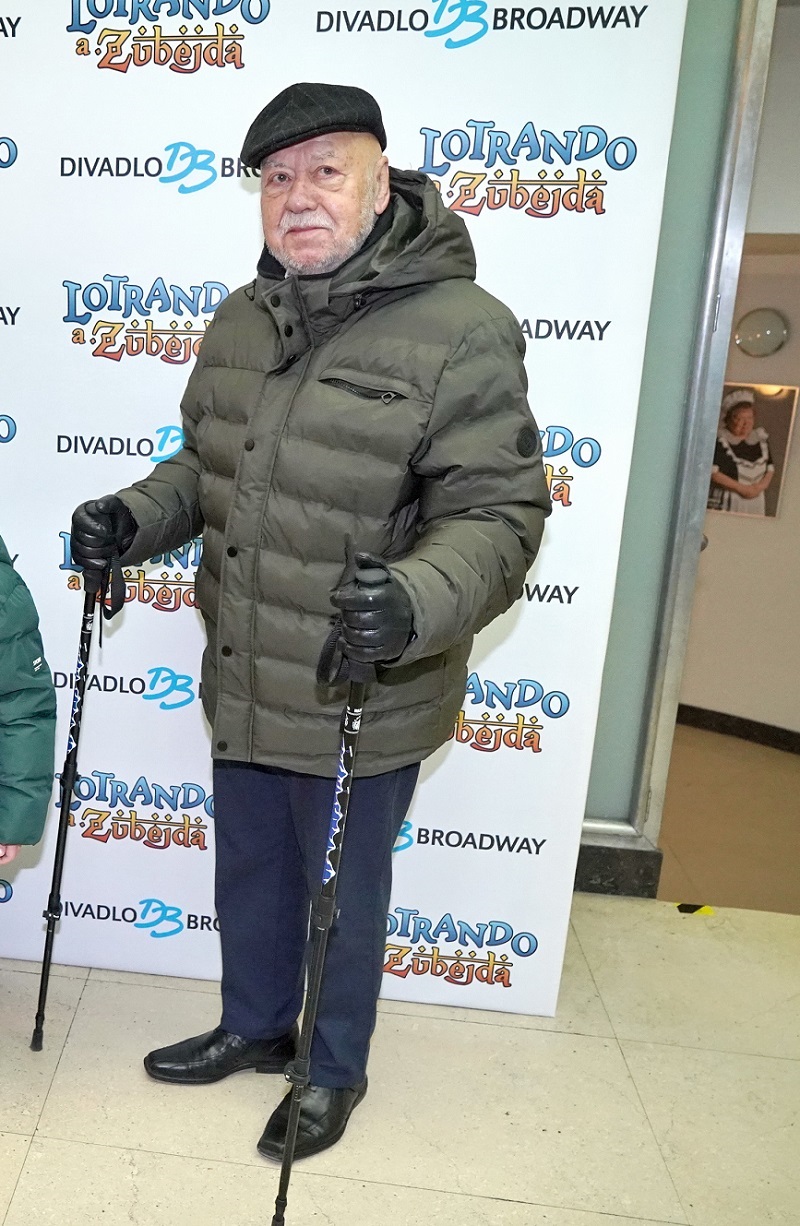 Toto jsem moc nepochopila. Pan Václav Hybš tam asi právě dorazil z výšlapu a omylem ho vyfotili u fotostěny. Takhle se na premiéru určitě nechodí. Není na tom nic slavnostního, snad až na tu obuv. Možná se jen nestihl převléknout a pod tím má trendy oblek. Těžko říct.