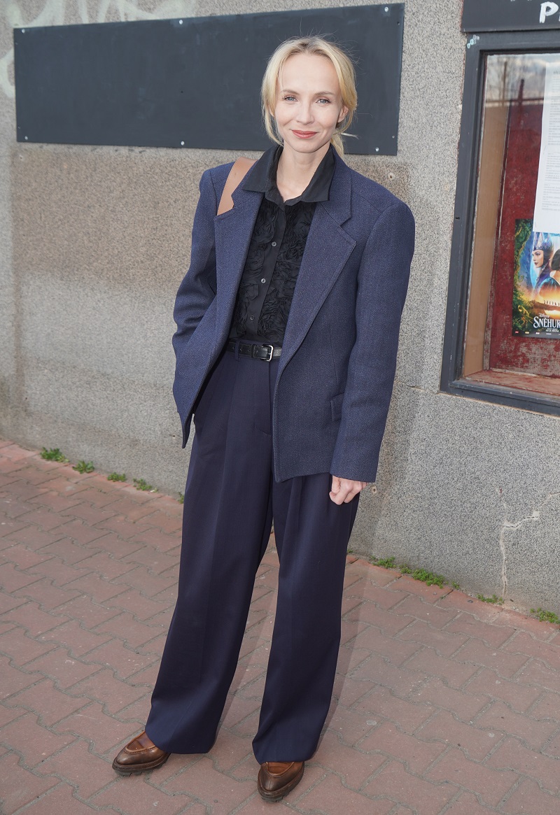 Jsem nadšená outfitem Jany Plodkové. Ryze pánský styl je osvěžen zdobenou dámskou halenkou. Líbí se mi kombinace materiálů a odstínů modré. Jediný drobný detail, který by mohl být lepší, je sladění pásku s botami.